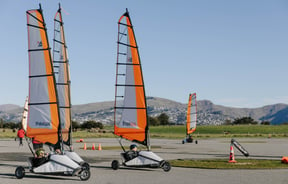 Go-karts with sails moving around a track in Christchurch.