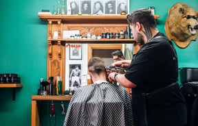 Barber giving man a hair cut.
