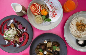 Birds-eye view of four dishes on a pink table at Bonobo, Christchurch.