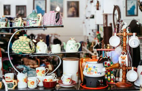 Vintage cups and teapots on shelves.