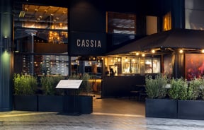 The black entrance to Cassia restaurant on a rainy day.