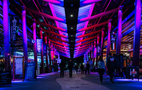People walking under purple lights at Eat Streat in Rotorua.