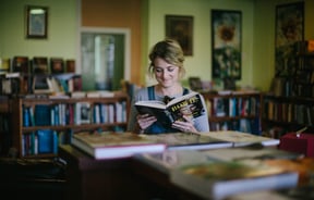 A woman reading a book about David Bowie.