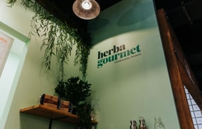 A painted Herba Gourmet sign on the interior wall.