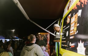 Alok laughing with customers at his food truck.