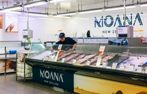 Moana mural behind lady at the fish counter.