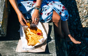 Woman eating fish and chips.