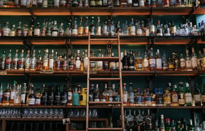 Close up of liquor bottles on a shelf.