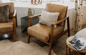 A leather armchair with a sheepskin cushion at Wilson & Dorset, Wānaka.
