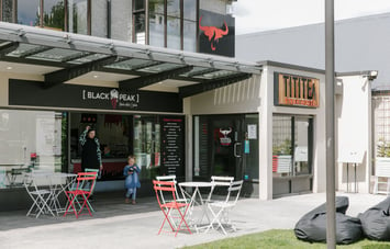 The exterior of Black Peak Gelato with tables and chairs and beanbags for customers.