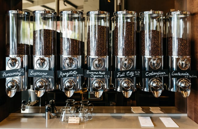 Coffee beans in glass dispensers.