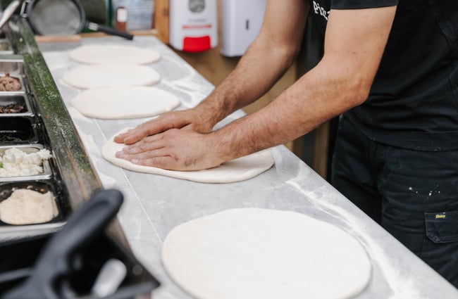 Man making pizza bases from dough at Arbour in Lyttelton.