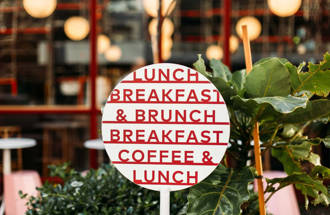A lunch, breakfast and coffee sign outside August Eatery.