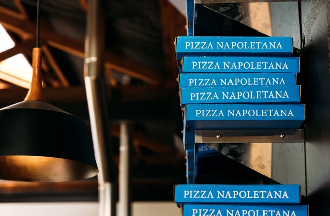 Blue pizza boxes stacked on top of each other.