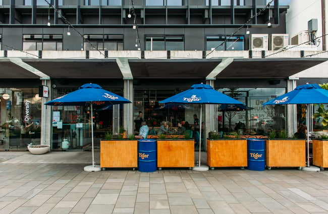 The exterior of Banh Mi restaurant with blue umbrellas out the front.
