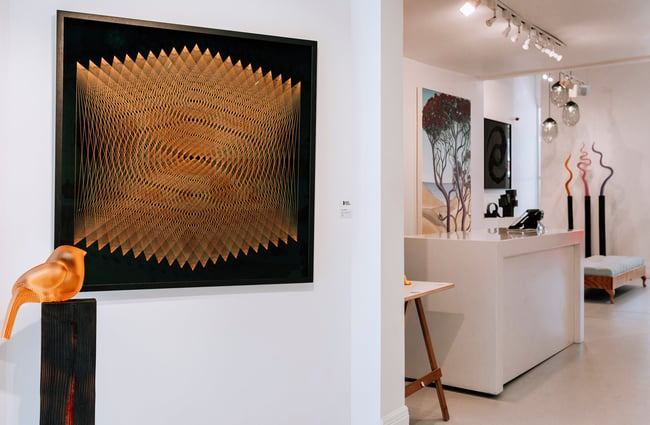 Various artworks on display including a glass bird in the foreground at Black Door Gallery, Auckland.