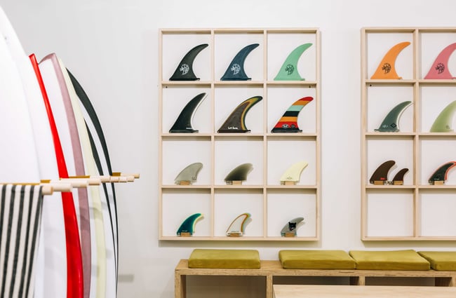 Surfboard fins on display against a white wall.