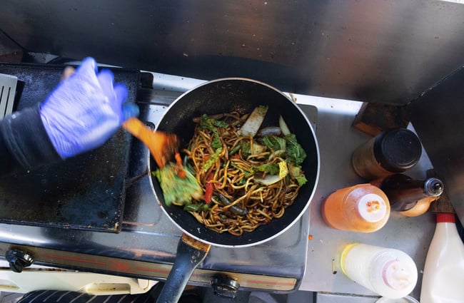 A birdseye view of noodles being cooked on a stove.