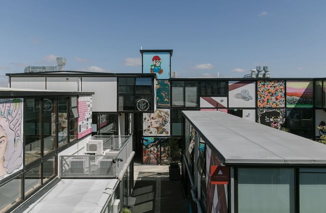 View from an upper level of BOXed Quarter down to an empty laneway; large format artworks line the vertical and horizontal square building faces beyond.