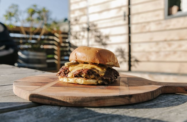 Close up of a fresh beef burger on an outside table.