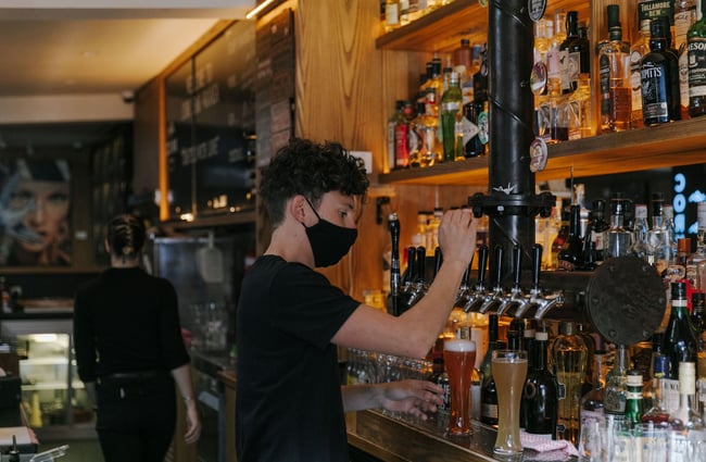 Man pouring drinks at the bar at Cork, Wānaka.
