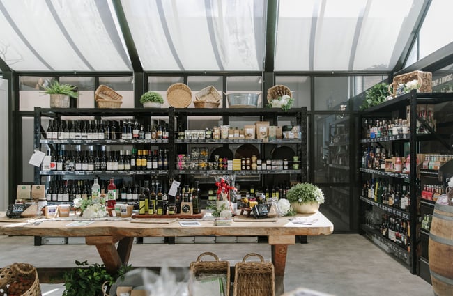 A table and shelves filled with artisan food and beverage products.