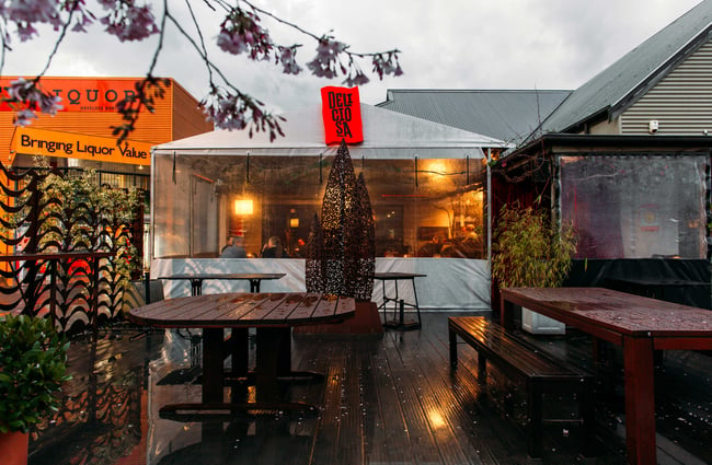 The covered outdoor seating ares on a rainy day.