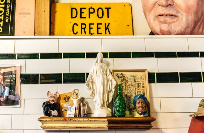 Shelf in front of white tiles and a yellow depot sign.