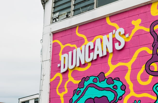 A close up of colourful Duncan's sign painted on a wall.