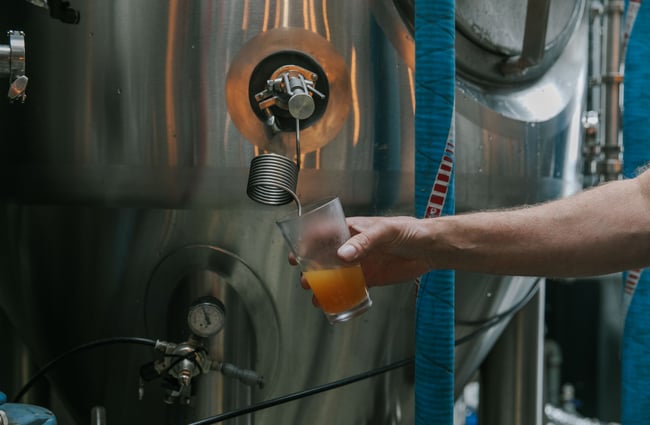A close up of beer being poured from the still.