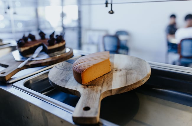 Wedge of cheese on a wooden board in Christchurch.