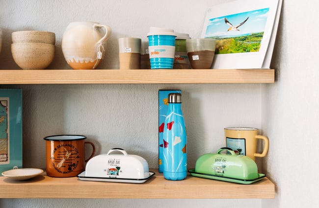 A close up of colourful homewares for sale on floating shelves.