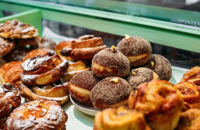 A close up of donuts and pastries in a cabinet.