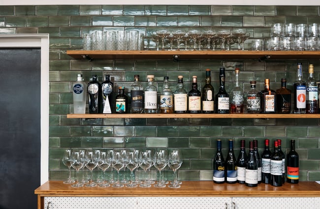Clean glasses and bottles of spirits behind the bar at Hayes Common, Hamilton.
