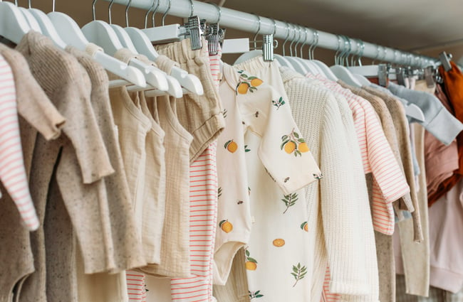 A close up of baby clothes on a rack.
