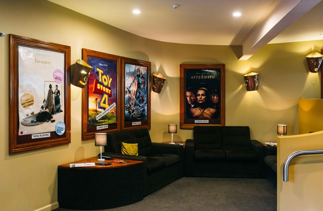 Movie posters on the yellow walls of the cinema.