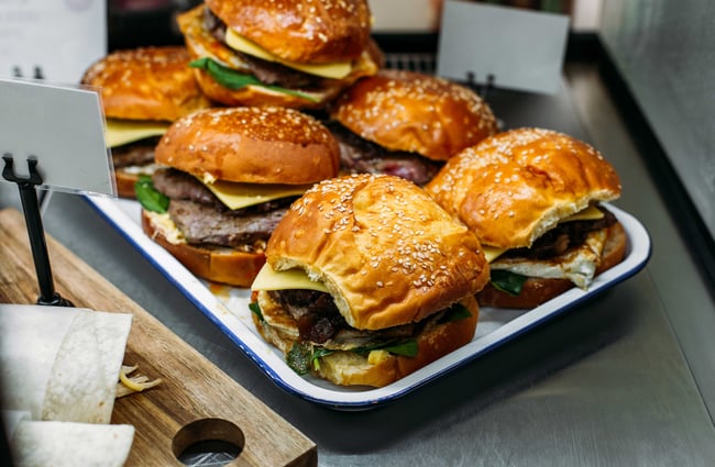 A close up of burgers in the counter.