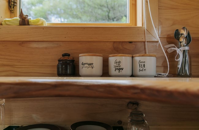 A close up of tea and coffee cannisters inside Maitai Whare Iti cabin.