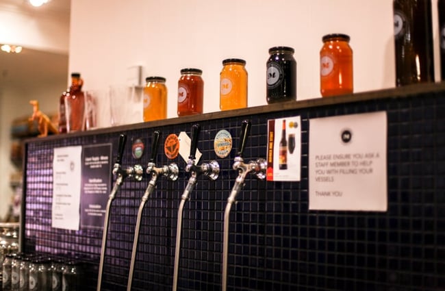 Coloured jars on top of the wall of tap beers.