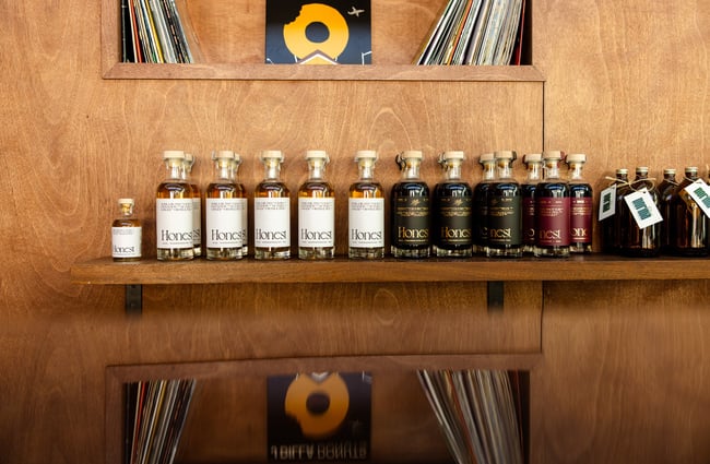 A close up of bottles of liquor on a wooden shelf.