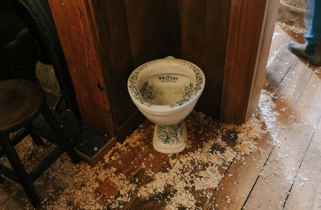 Old toilet basin with woodchips on the floor at Paddy McNaughton's, Christchurch.