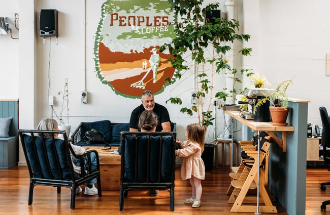 A man with child sitting on a couch at Peoples Coffee in Wellington, New Zealand.