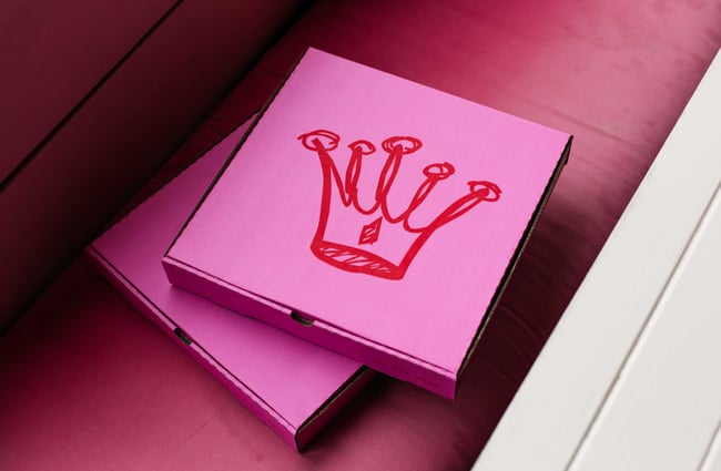 Pink pizza boxes on a seat.