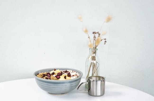 A bowl of porridge on a table against a white background.