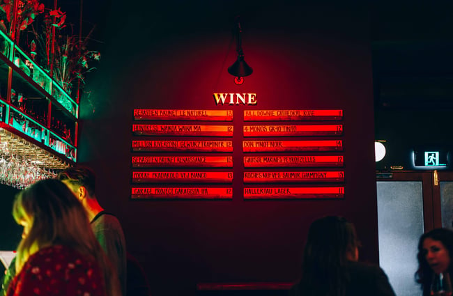 Red signs wine list on a brick wall.