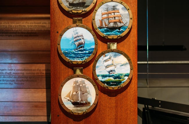 Close up of pictures of sail boats on a wall.