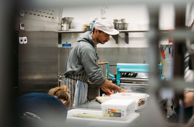 A male staff member working in a commercial kitchen.