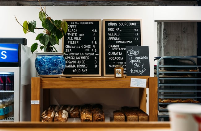 A close up of baked bread and signage on a wooden display.