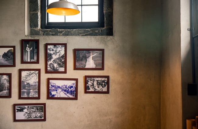A close up of framed pictures on a concrete wall.
