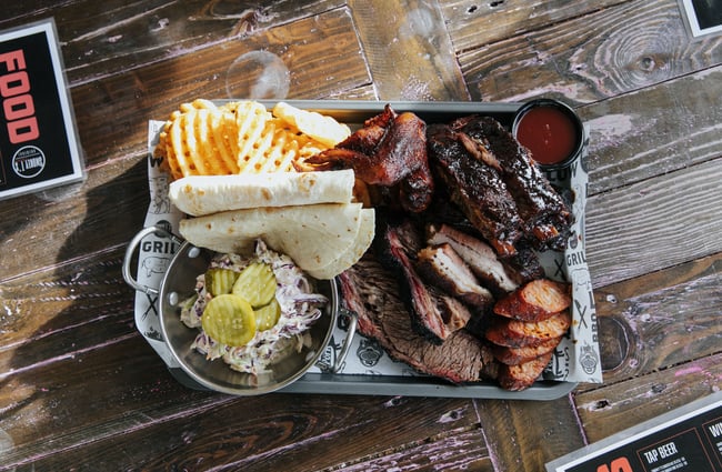 Flatlay of BBQ meat and chips on a table.